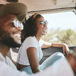 Couple on a roadtrip laughing with each other